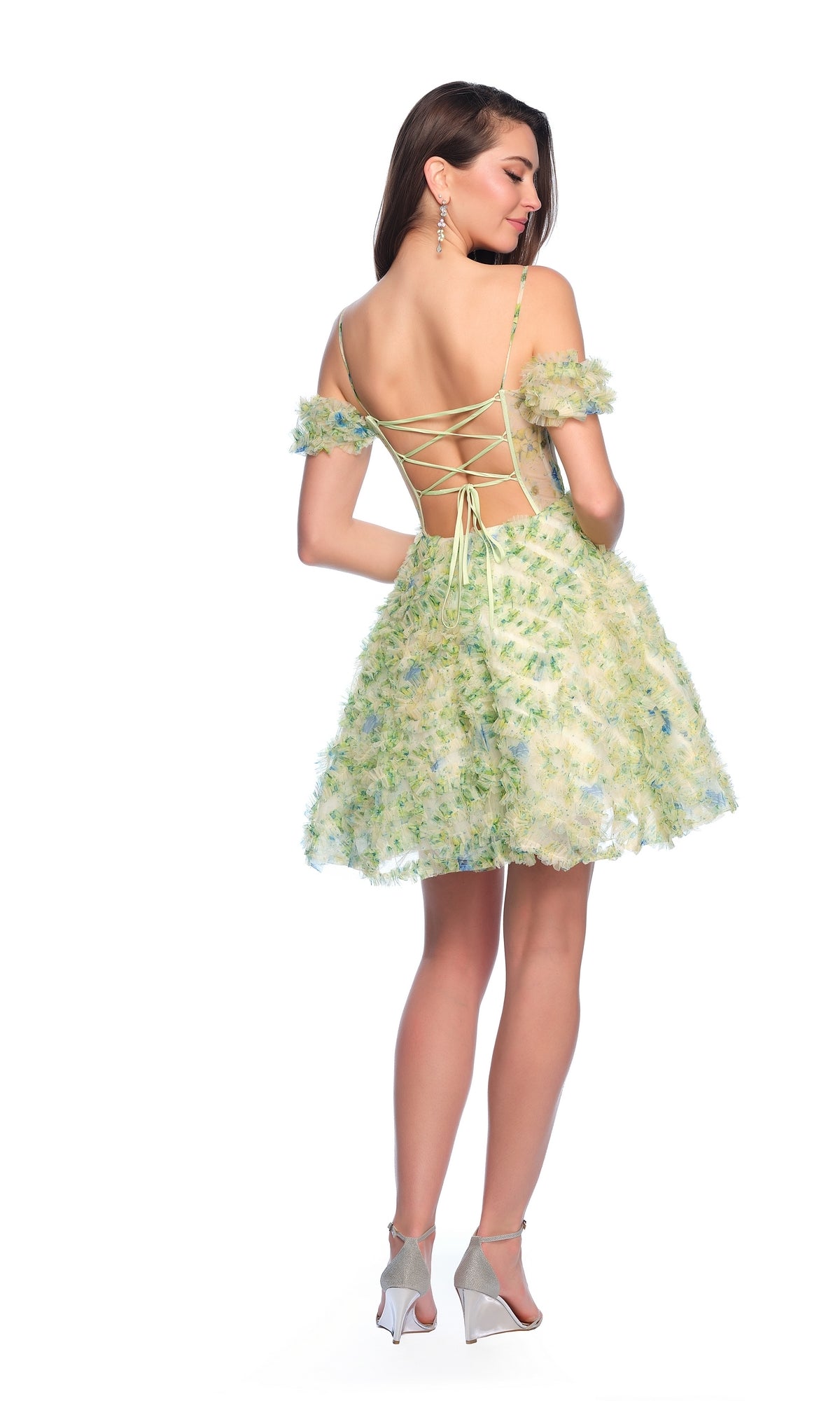 A woman stands in heels against a white background wearing the Dave and Johnny Short Green Print Hoco Dress 11767, featuring off-shoulder sleeves, a lace-up open back, and a floral print.